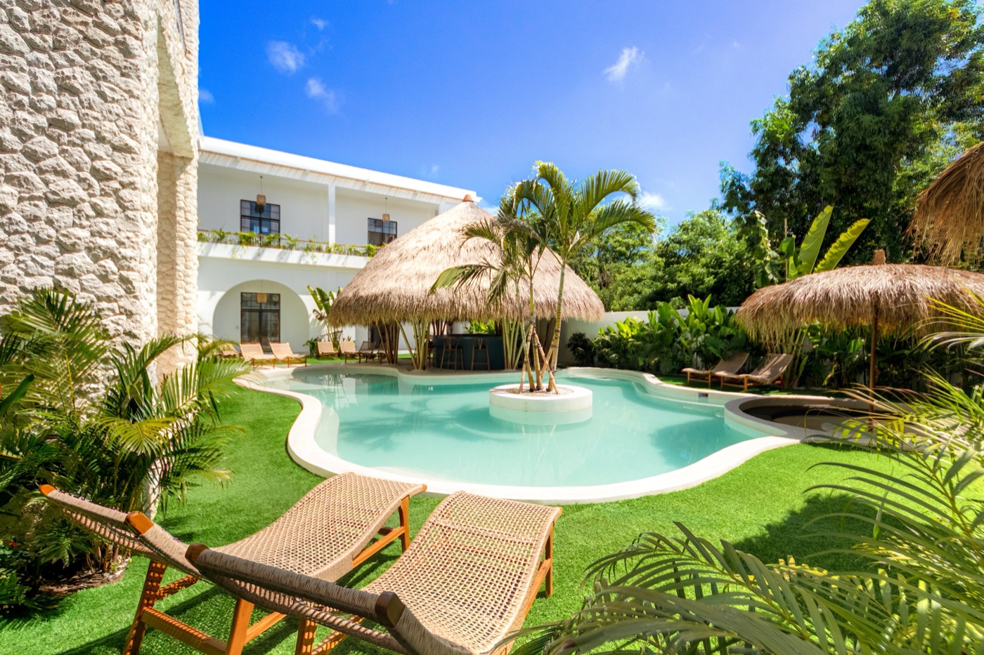 Lagoon pool with palm island and thatched bar